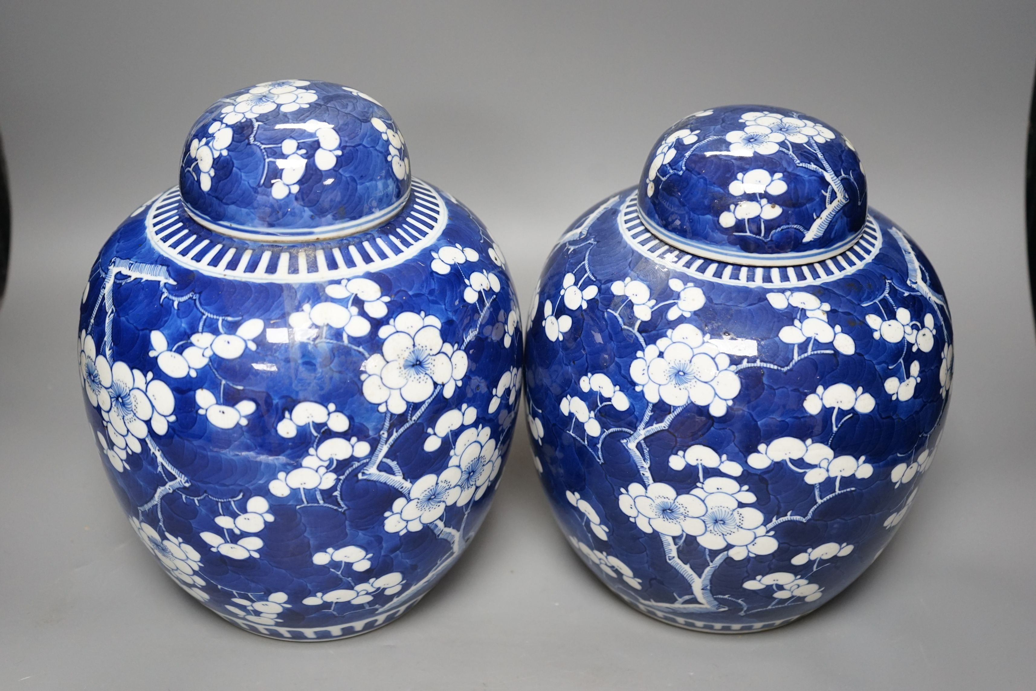Two Chinese 20th century prunus jars and covers, 27cms high